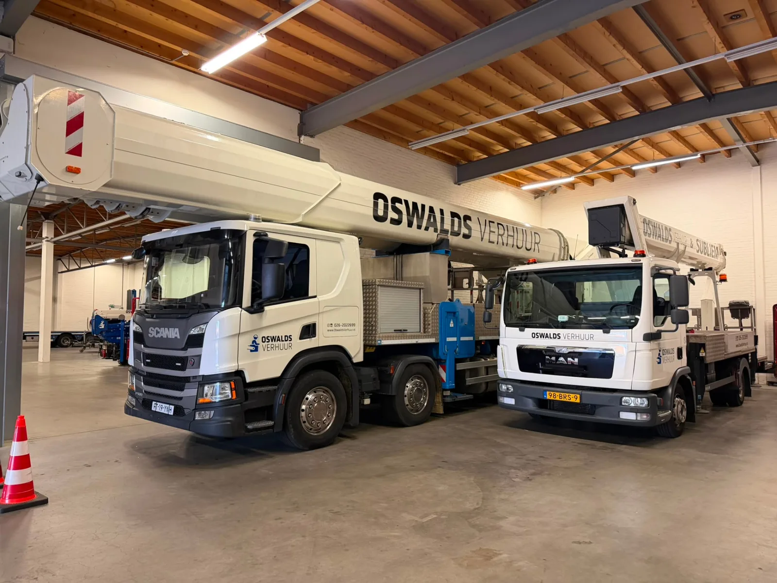 90 Meter RUTHMANN T900HF mit Oswalds Beschriftung neben einer kleineren LKW-Arbeitsbühne in der Halle in Arnheim